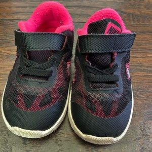 Well loved. Black and pink Nike shoes.